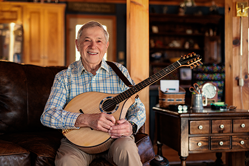 Terry playing a banjo sitting on the couch