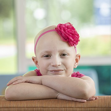 Ellee Portrait, smiling with red flower bow