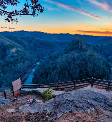 Photo of a hiking trail high up on a mountain, overlooking a river