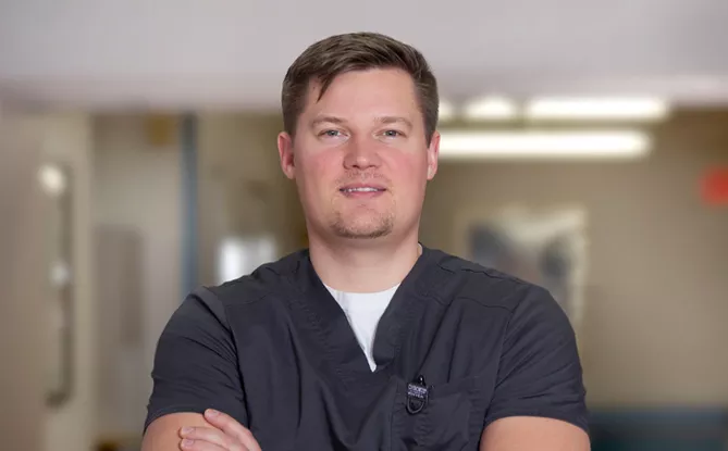 Male nurse smiling with his arms crossed